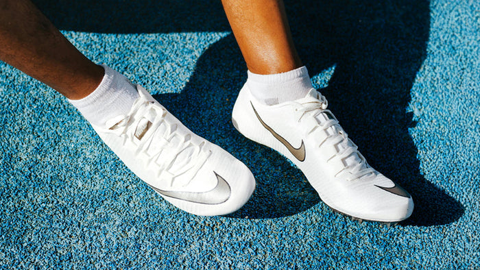 image of someone's feet wearing white shoes on a track