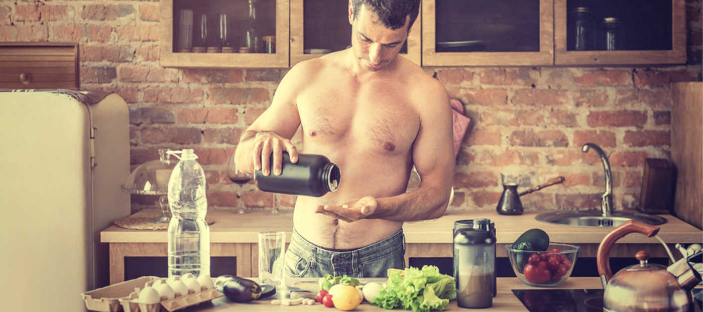 Athlete taking supplement in kitchen