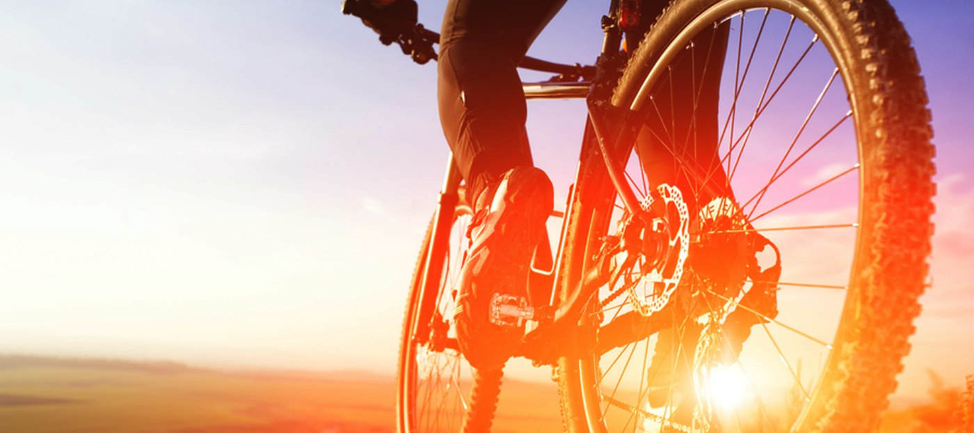 cyclist riding into sunset