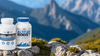 Two bottles, labeled “Altitude RX” and “Altitude Boost,” sit on a rocky surface with blurred green mountains in the background.