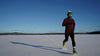 man dressed warmly running in the snow